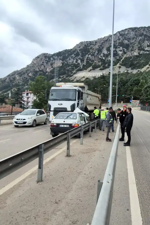 Kamyonun altına giren otomobilden yara almadan çıktılar